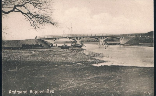 Amtmand Hoppes Bro ca. 1906. Bemærk det helt åbne afgræssede landskab omkring broen og kåg-prammen som bliver lastet lige ved broen.
Foto: Langå Arkiv.