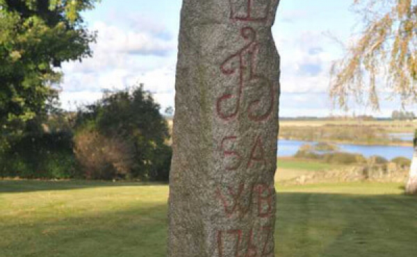 Stenens tekst står flot opmalet med rød farve.