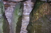 Flot delestenen med omgivende tørmur mellem bæresten i gravkammeret.